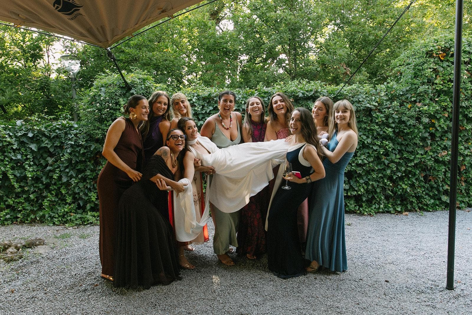 Amigas levantando a la novia entre risas